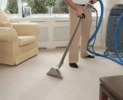 Carpet cleaning professional removing dirt and stains with a hot-water extraction tool in a home, San Antonio, TX.