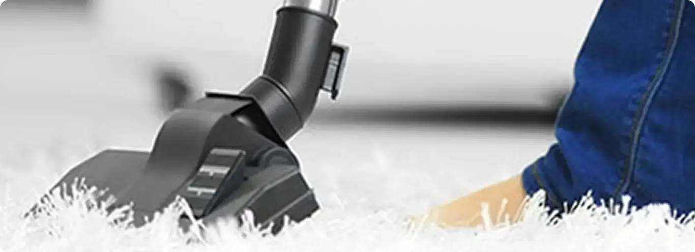 Close-up of a professional vacuuming a white carpet in Von Ormy.